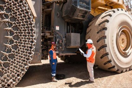 Plusmining Mineros al costado de camión minero