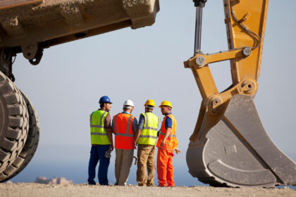 Mineros junto a una retro excavadora