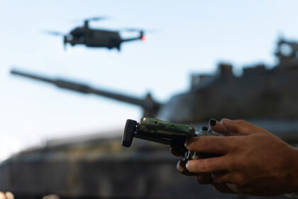 industria militar impulsaria demanda por cobre manos sosteniendo un control remoto